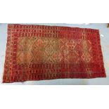 An Eastern rug, the red field with multiple flowerhead borders, 110 x 200cm