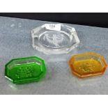 A clear glass intaglio cut ashtray, together with two coloured glass pin dishes, (3)