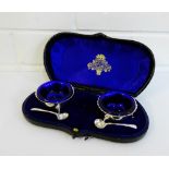 Edwardian pair of circular silver salts with blue glass liners, Chester 1901, in original fitted