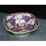 A small Chinese dish of quatrefoil form on a circular footrim, painted with Phoenix, Bats and