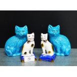 A pair of Staffordshire style pottery cats, modelled seated on blue cushions, together with a pair