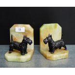 A pair of Art Deco hardstone bookends mounted with black painted Spelter Scottie Dogs, 12cm high, (