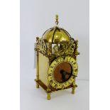 A brass clock, the chapter ring with Roman numerals, 18cm high