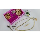 A collection of costume jewellery to include faux pearls, jade brooch, gold plated locket and