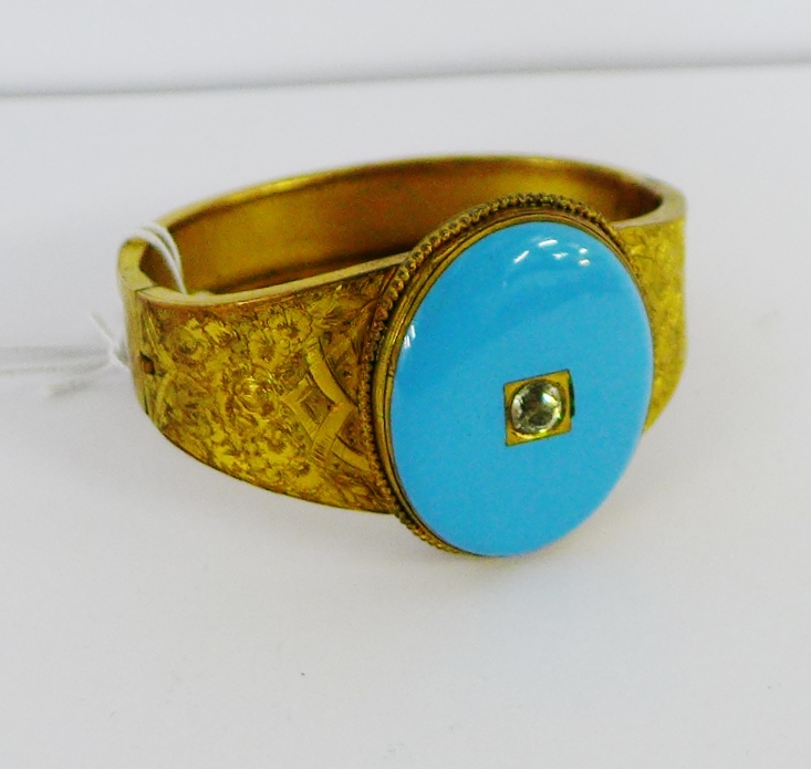 A vintage gold plated bangle with an oval turquoise panel