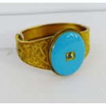 A vintage gold plated bangle with an oval turquoise panel