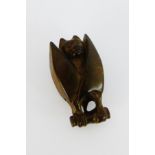 A carved wooden Netsuke in the form of a bat