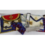 A collection of Masonic regalia to include three aprons, a sash and a gilt metal medal and a