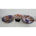 Three Imari scalloped bowls of graduating size together with one small hardwood stand, large bowl