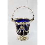 An early Victorian silver sweetmeat basket with laurel leaf swags, swing handle and original blue