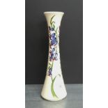 Moorcroft vase tube line decorated with blue flowers against a cream ground, circa. 2009, 31cm high