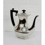 George V silver coffee pot with half gadroon decoration and raised on four bun feet with makers