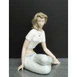 NAO porcelain figure of a Girl with capri pants and cropped top, modelled seated with cross legs,