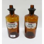 Two brown glass pharmacy jars and stoppers with gilt edged enamelled syrup labels, 23cm tall, (2)