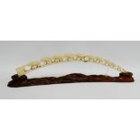 Carved ivory elephant train on a hardwood stand, (a/f), 69cm long