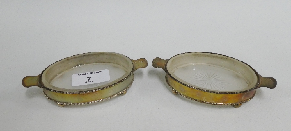 A pair of George V silver and glass oval butter dishes, Chester 1911, 13cm long (2)