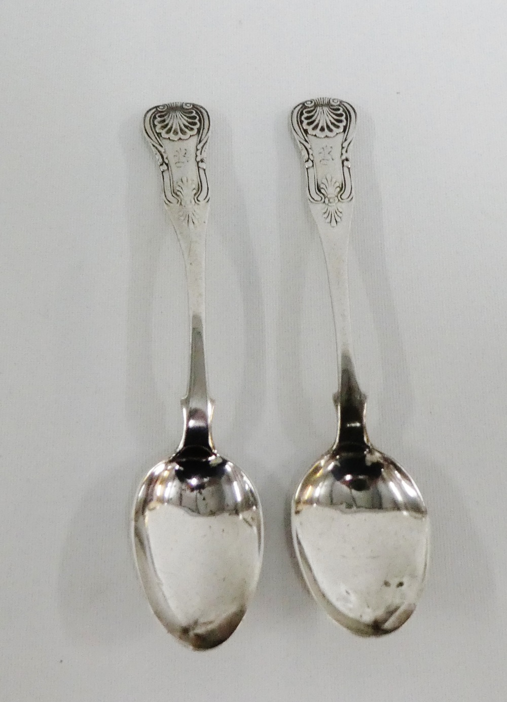 A pair of early 19th century Kings pattern silver teaspoons with TL, saltire, anchor and J