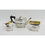 George V silver three piece teaset comprising teapot, sugar bowl a and cream jug, all on four bun