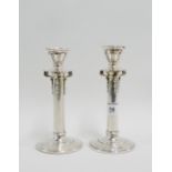 A pair of George V silver candlesticks with scrolling supports and plain stem and footrim by W & F