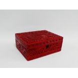 Chinese red cinnabar box with carved village scene and foliage to top, 25 x 18cm