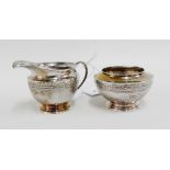 Liberty & Co silver sugar bowl and milk / cream jug, each with a hammered finish and feathered