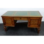 Carved oak desk, the rectangular top with three leather skivvers, over a central drawer and pair