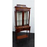 Mahogany display cabinet with glazed doors and shelved interior over a pair of short drawers and