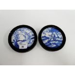 Two circular framed blue and white tiles depicting St. Francis and St. Peter, in ebonised frames and