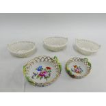 Two Dresden porcelain reticulated baskets painted with flowers, together with three German cream