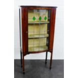 Edwardian mahogany and inlaid display cabinet with a glazed door and shelved interior, raised on