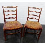 Pair of mahogany ladderback chairs with worn leather seats, 75 x 58cm, (2)