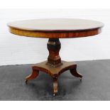 Mahogany circular top table on square column and quadripartite base with brass castors 73 x 106cm