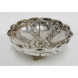 Greek silver bowl of circular scalloped form with repousee floral panels, raised on three out