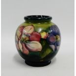 Moorcroft vase of squat globular form, the green and blue ground tube line decorated with flowers,