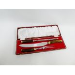 Horn handled three piece carving set in a red leather fitted box