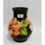 Walter Moorcroft porcelain vase, tubeline decorated with flowers to a green ground, 24cm high