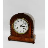 Oak cased mantle clock, the domed top over the enamel dial with Arabic numerals flanked by barley