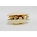 Early 20th century carved ivory shell, the interior carved with figures, signed to the base, 8cm