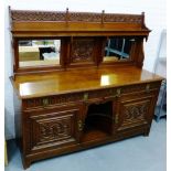 Oak mirrored back sideboard, the rectangular top with moulded edge over an alcove and arrangement of