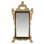 An Italian Rococo style parcel-ebonized carved giltwood pier mirror 20th century H: 60, W: 31 in.