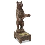 A Black Forest carved walnut bear-form umbrella stand late 19th century H: 50, W: 16, D: 20 in.