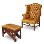 A George III style mahogany wingback chair and mechanical footstool with tufted leather upholstery