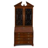 A George III mahogany secretary bookcase circa 1790 With divided pediment lacking urn finial over