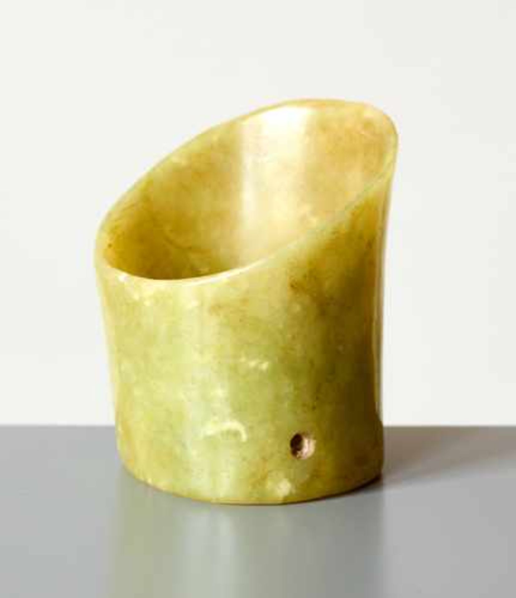 A SMALL HOOF-SHAPED (TI XING) SLANTED TUBE CARVED IN LIGHT GREEN JADE Jade, China. Late Neolithic