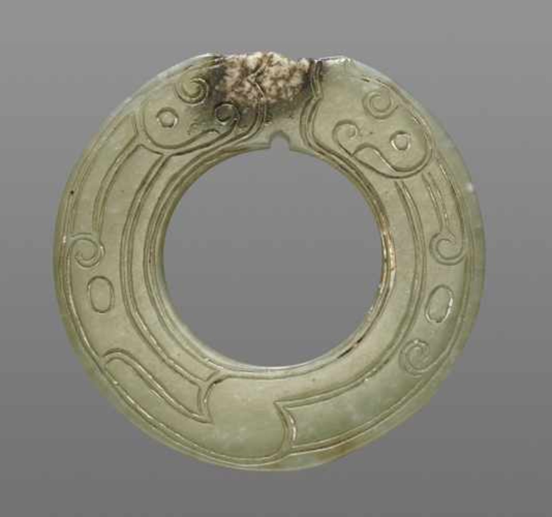THIN AND DELICATE GREEN JADE RING WITH AN INCISED PATTERN OF STYLIZED DRAGONS Jade, China. Late - Image 2 of 6