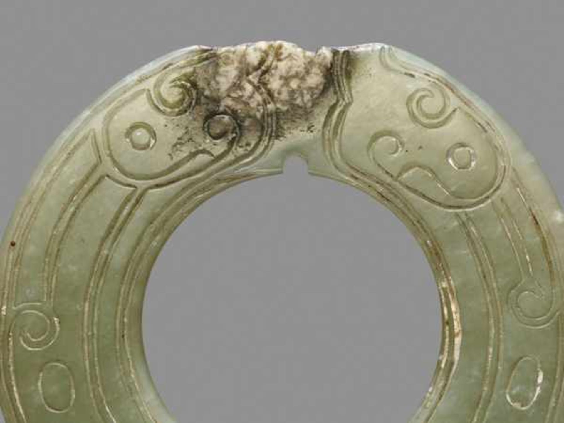 THIN AND DELICATE GREEN JADE RING WITH AN INCISED PATTERN OF STYLIZED DRAGONS Jade, China. Late - Image 4 of 6