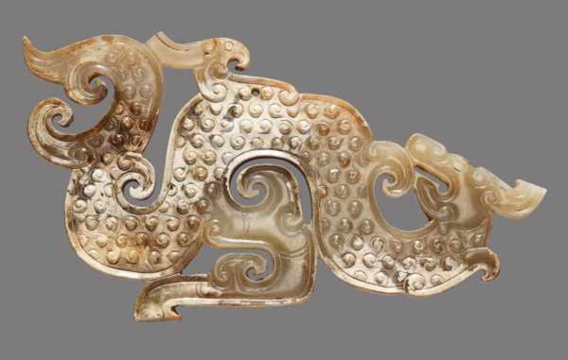 A SINUOUS S-SHAPED DRAGON WITH A PHOENIX AND CURLED APPENDAGES Jade, China. Eastern Zhou, 5th -