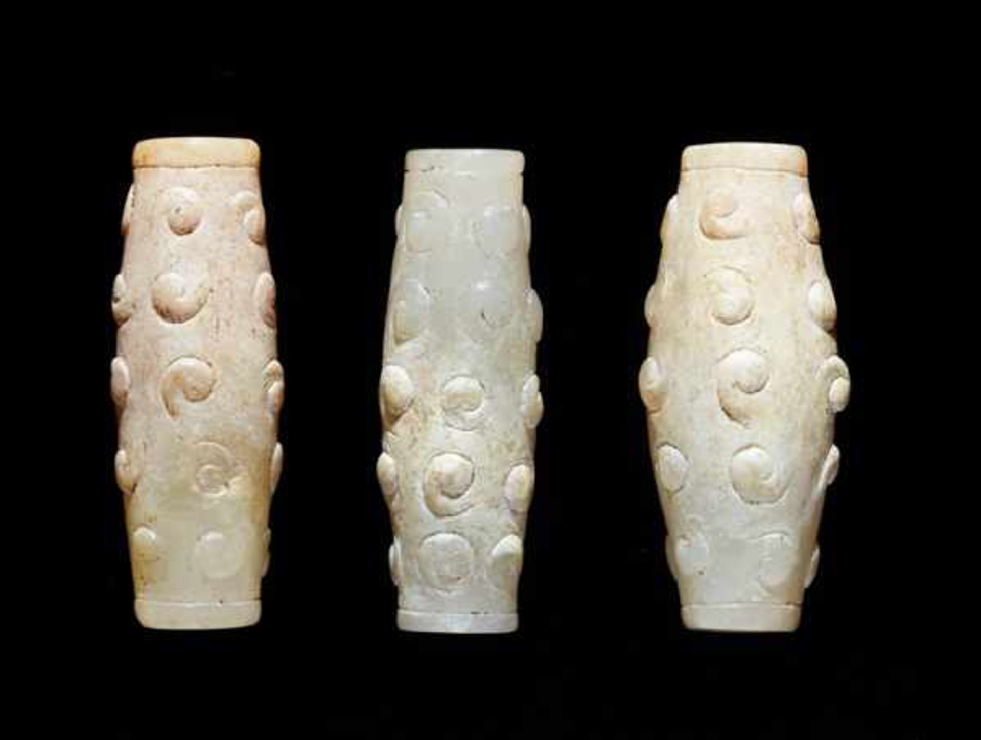 THREE TINY BEADS IN WHITE JADE WITH DELICATELY CARVED SCROLLS IN RELIEF Jade, China. Eastern Zhou,