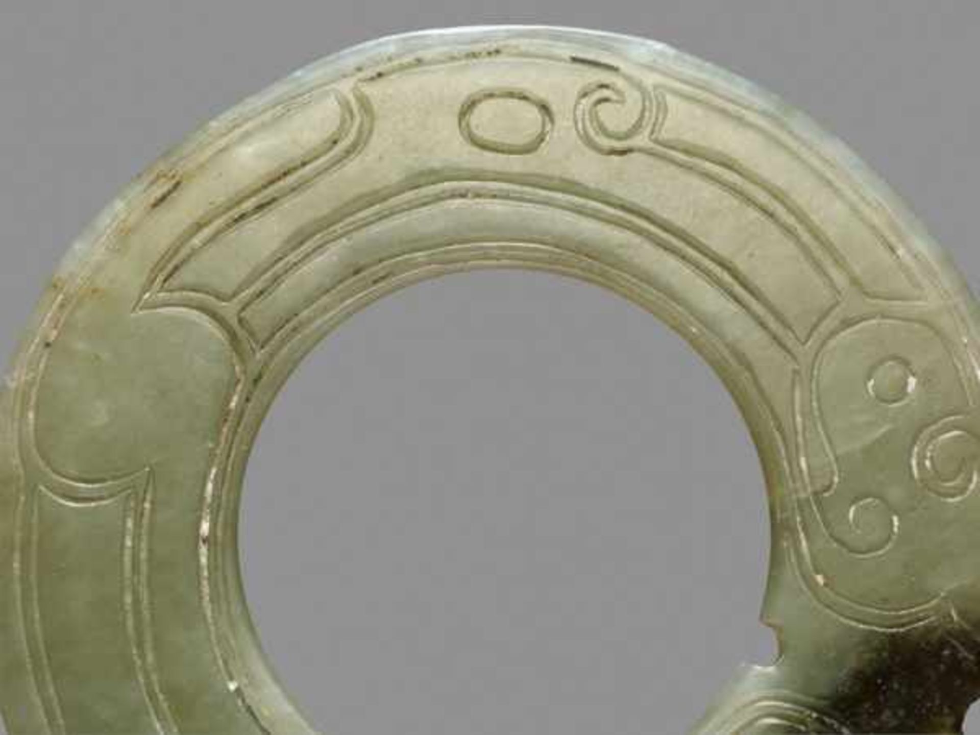 THIN AND DELICATE GREEN JADE RING WITH AN INCISED PATTERN OF STYLIZED DRAGONS Jade, China. Late - Image 3 of 6