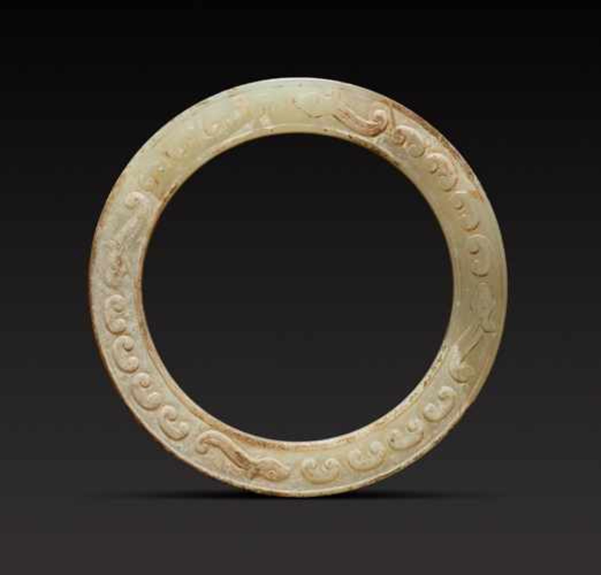 A BEAUTIFUL THIN RING DECORATED WITH DRAGONS AND CLOUD-SHAPED SCROLLS, JUANYUN Jade, China.